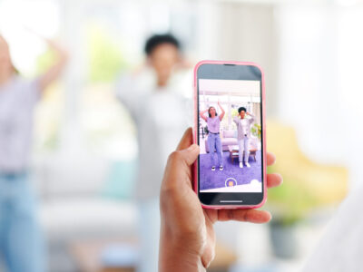 Woman, phone and friends live recording of influencer for social media, vlog or online post dancing.